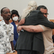 Vincent Ellerbe, left, approaches as Thomas Malik, right, embraces his lawyer Ron Kuby, center, following an exoneration hearing at Brooklyn Supreme Court, Friday July 15, 2022, in New York.